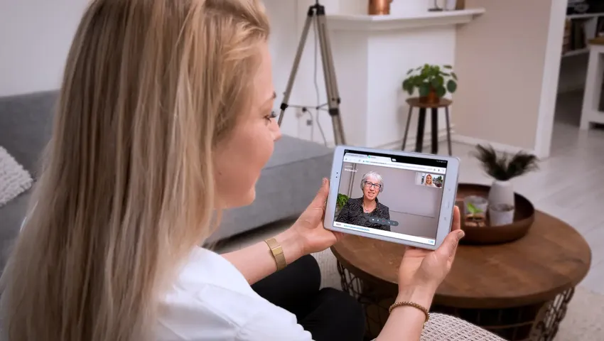 Vrouw beeldbelt via WeSeeDo op haar iPad met een cliënt.
