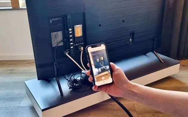 Iemand met een telefoon laat via WeSeeDo een probleem zien.